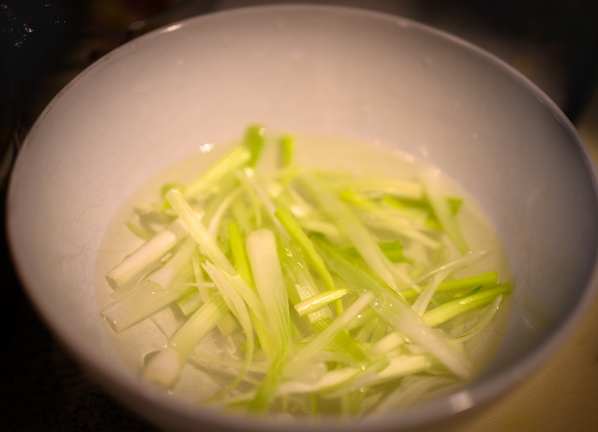 green onion strings soaking in water